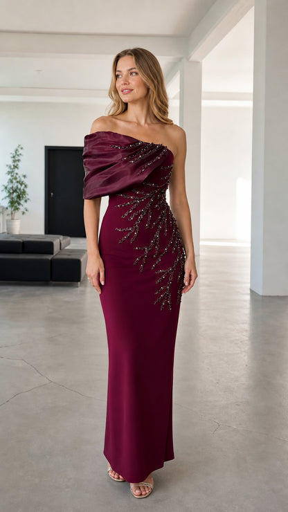 Front view of woman wearing burgundy asymmetric draped beaded evening maxi gown