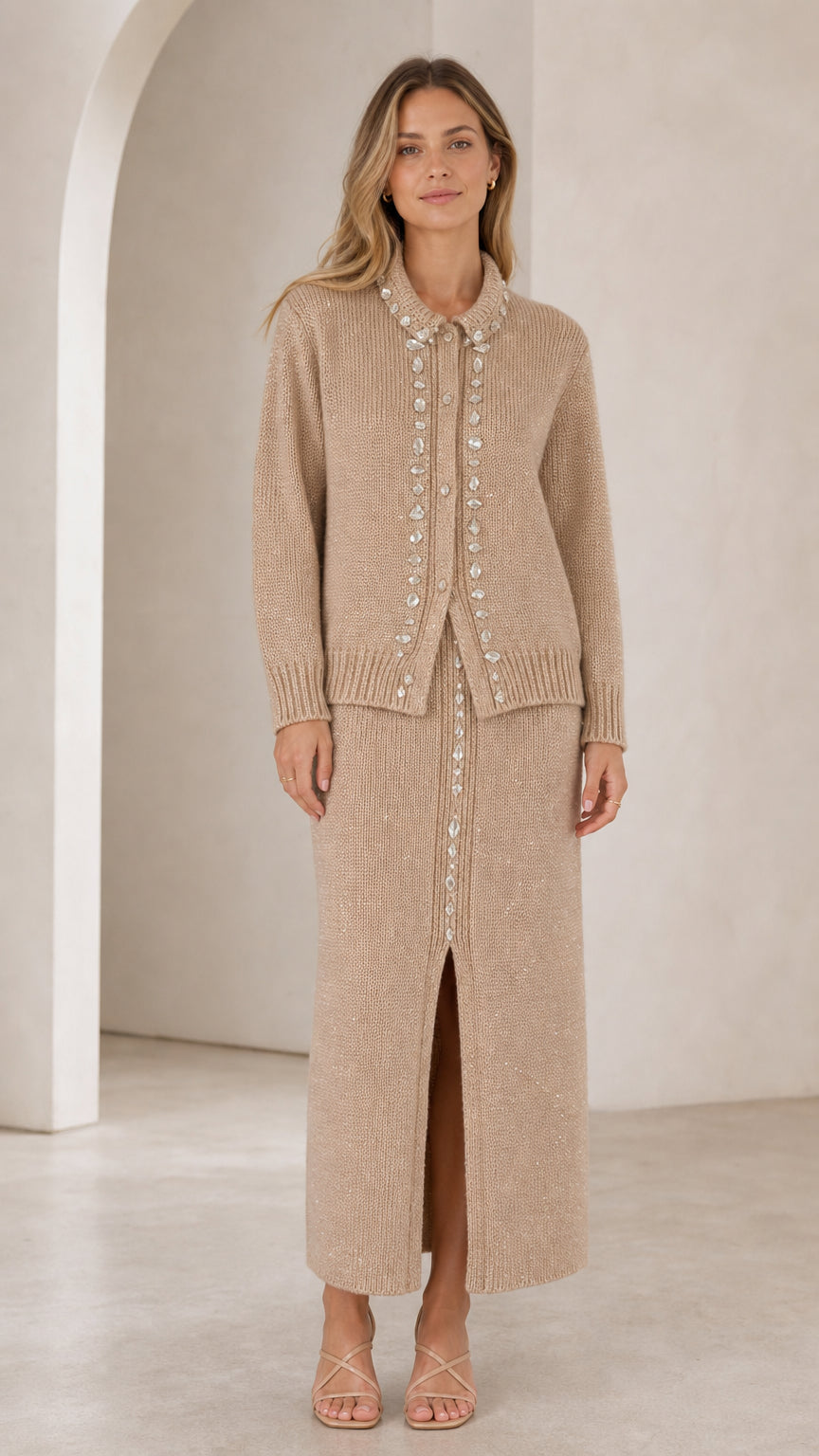Front full view of woman wearing beige rhinestone-embellished knit cardigan and slit maxi skirt set