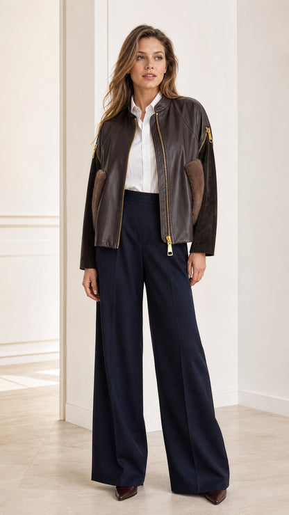 Front full view of woman wearing Dark Brown faux leather bomber jacket with plush pockets and navy trousers