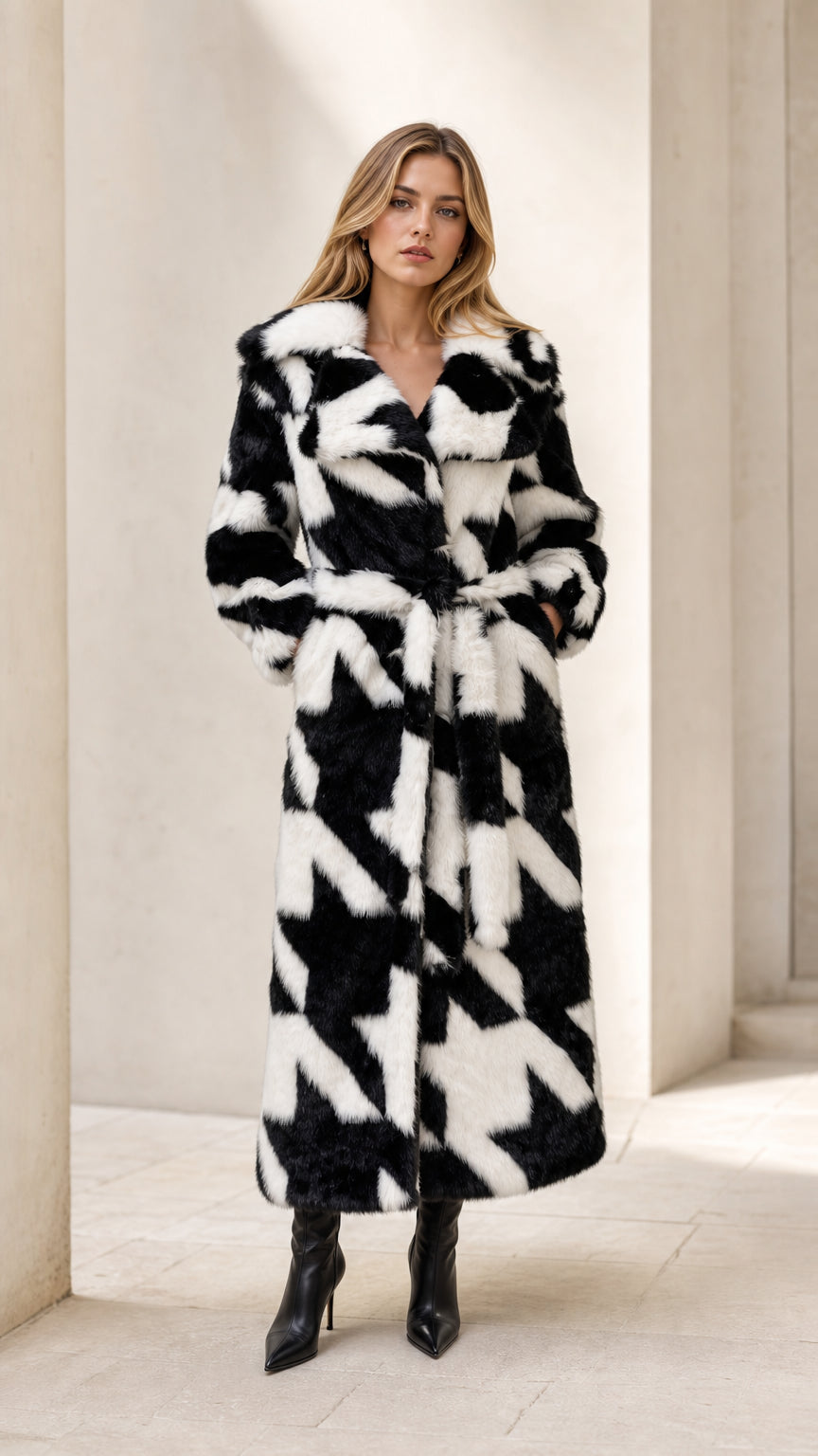 Full front view of model wearing black and white houndstooth faux fur belted maxi coat