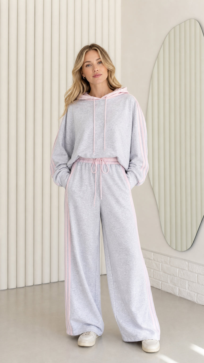 Front view of woman wearing Heather Grey two-piece tracksuit set with pink stripes and hood