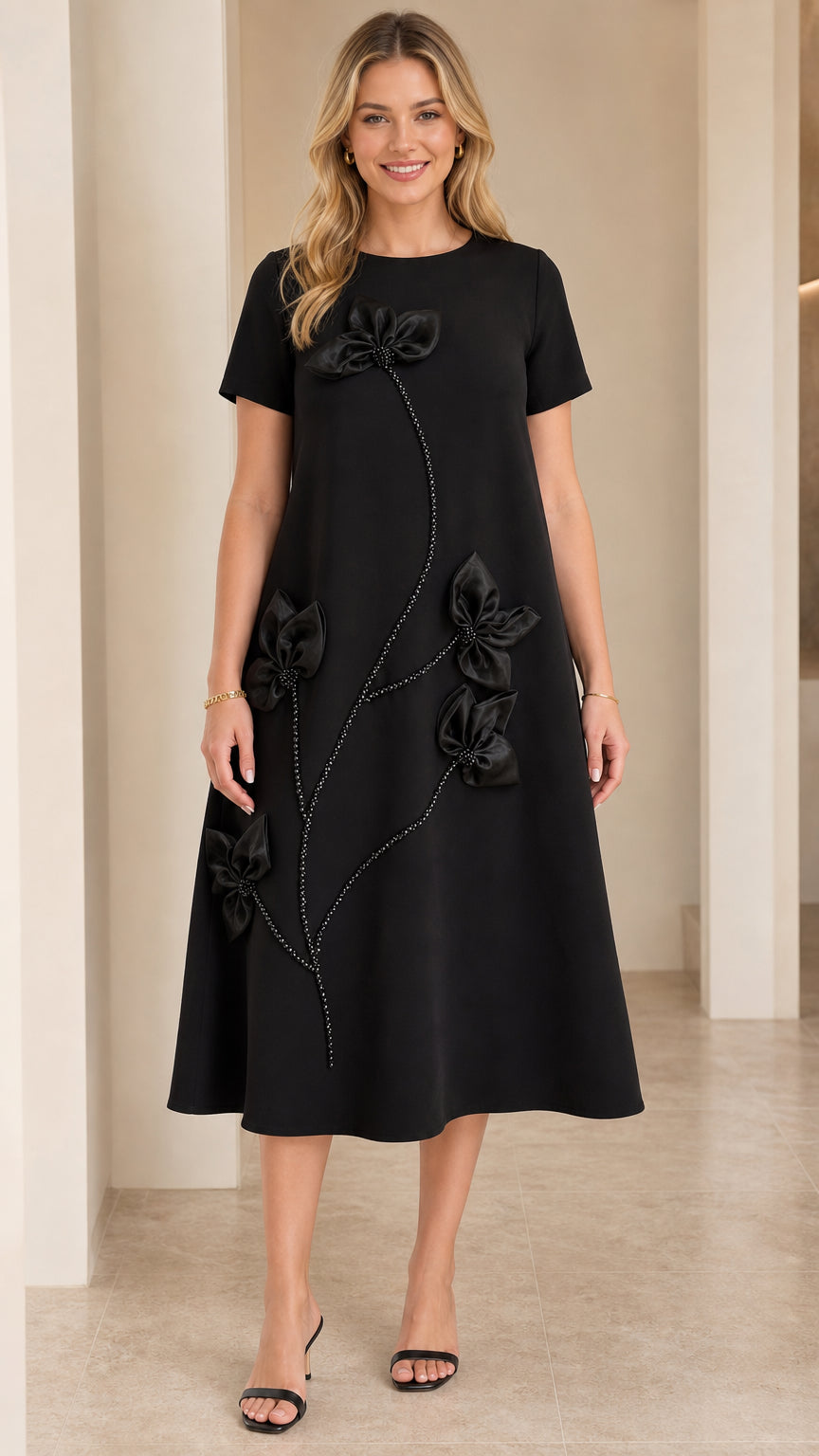 Front view of woman wearing Black short-sleeve A-line midi dress with 3D floral appliqué and beaded stem details
