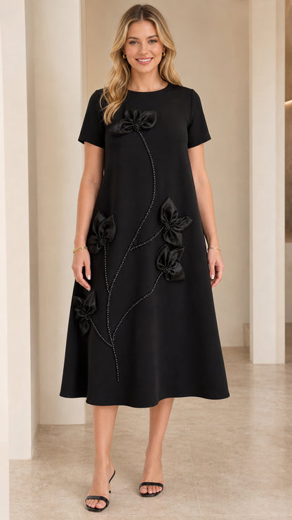 Front view of woman wearing Black short-sleeve A-line midi dress with 3D floral appliqué and beaded stem details