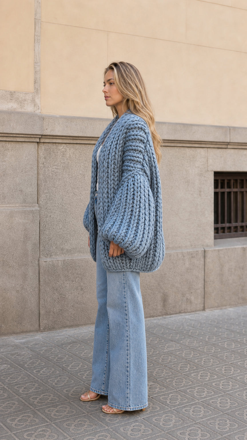 Side profile view of woman wearing oversized slate blue chunky ribbed knit cardigan