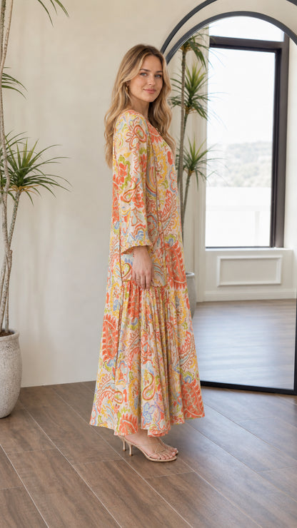 Side profile view of woman wearing bohemian yellow multi tiered maxi dress