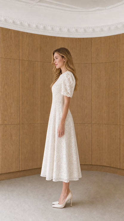 Side profile of model wearing white floral lace A-line midi dress with heels