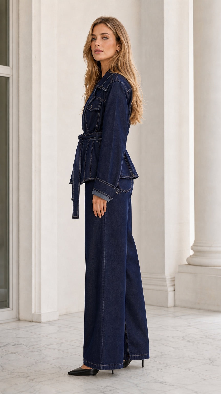 Side angle view of dark blue belted denim two-piece suit with contrast stitching