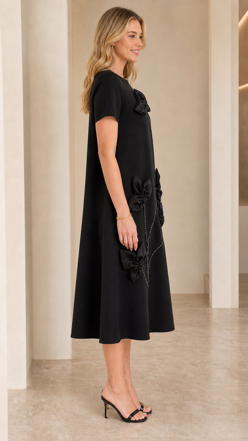 Side profile view of woman modeling Black 3D floral appliqué A-line swing dress