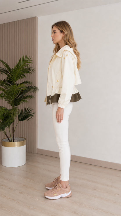 Side profile view of model wearing cream lightweight hooded utility jacket with white jeans