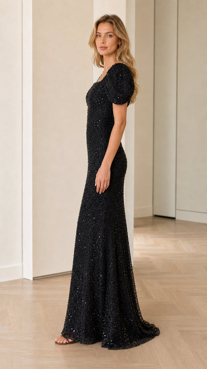 Side profile view of black floor-length sequin dress with puff sleeves