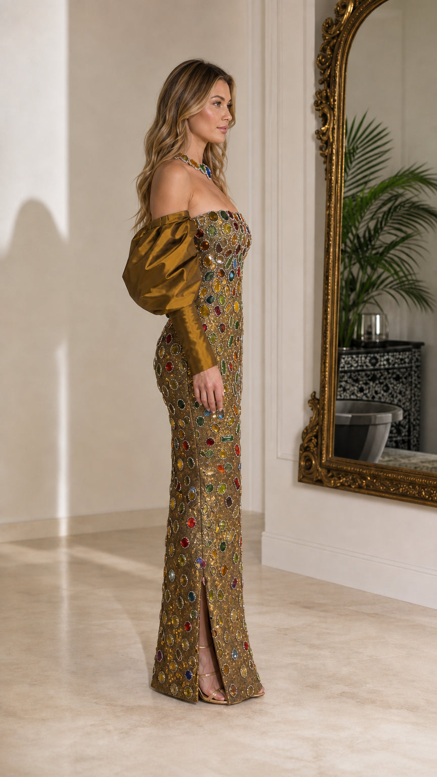 Side angle view of woman wearing gold jeweled column evening dress with puffed sleeves