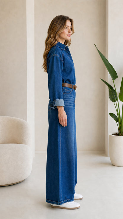 Side profile view of woman modeling Medium Blue long sleeve denim jumpsuit
