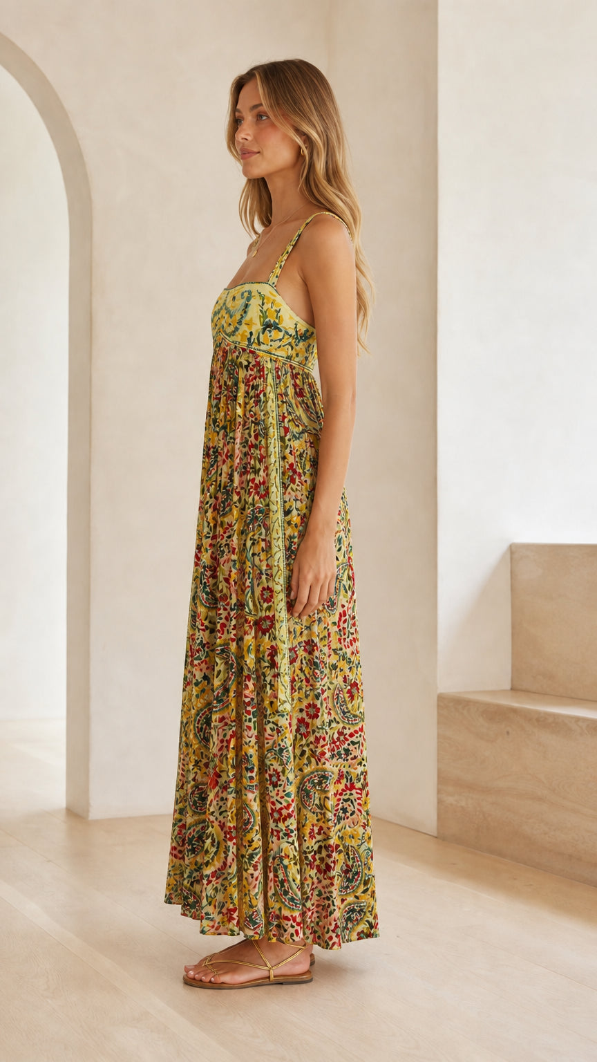 Side profile of model wearing yellow floral empire waist maxi dress