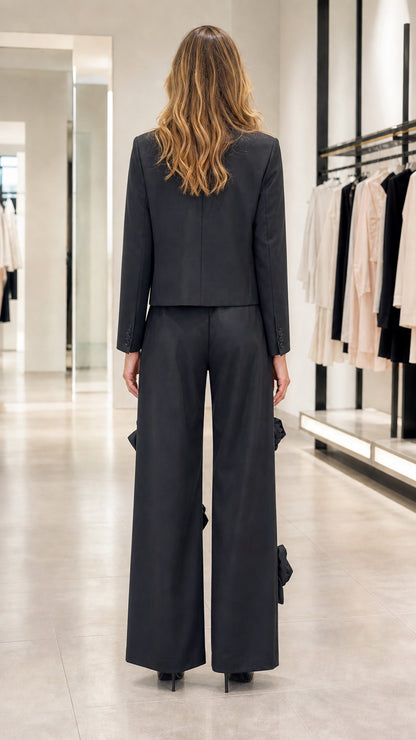 Model wearing black wide-leg trousers and cropped blazer set back view