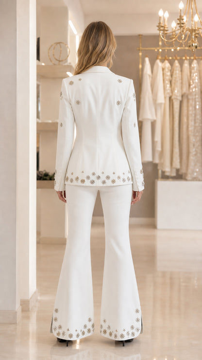 Back view of white tailored blazer and bell bottom trousers with embellished cuffs