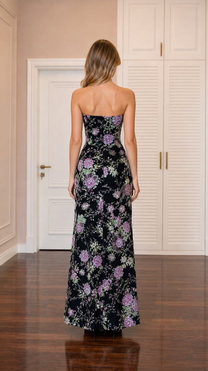 Back view of model wearing black strapless sequined floral evening gown