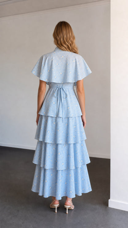 Back view of sky blue floral maxi dress showing waist tie and capelet back