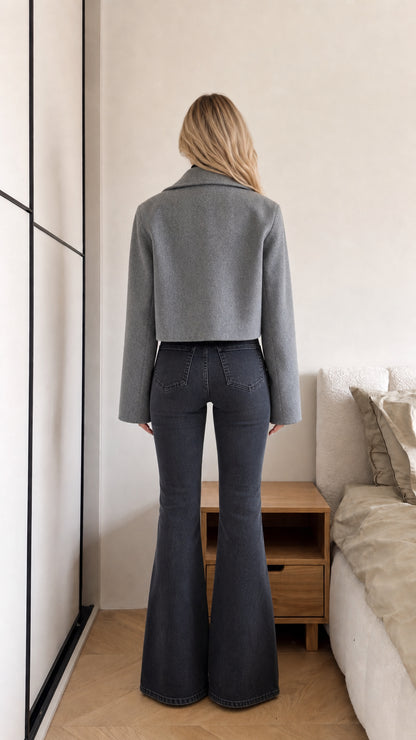 Back view of model wearing grey cropped coat highlighting clean shoulder line and waist-skimming hem