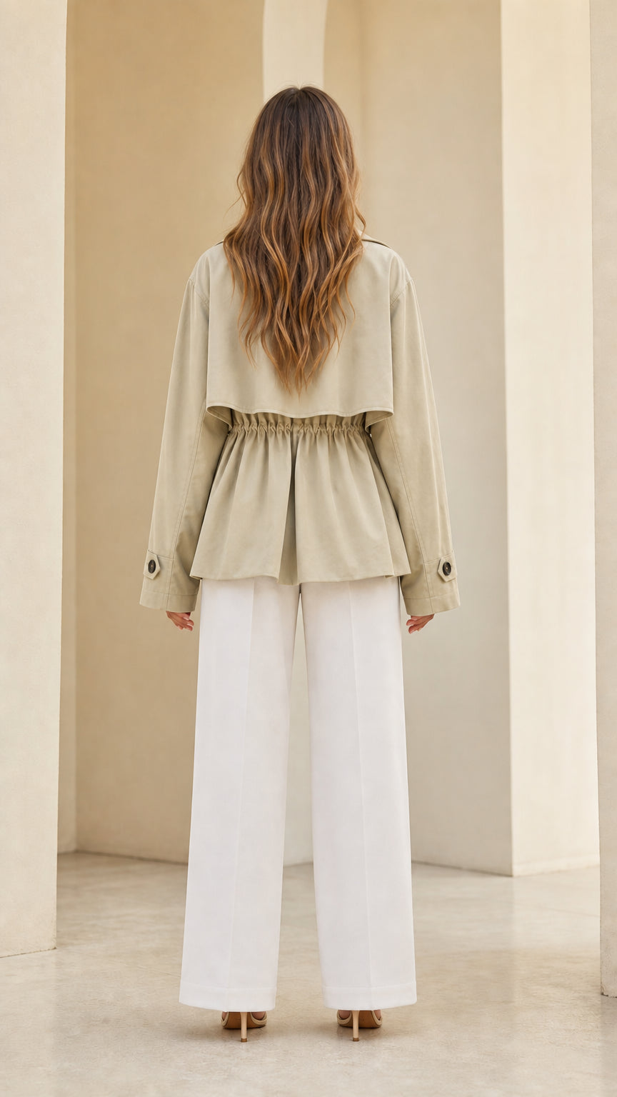 Back view of light khaki short trench coat showing gathered elastic drawstring waist and storm flap