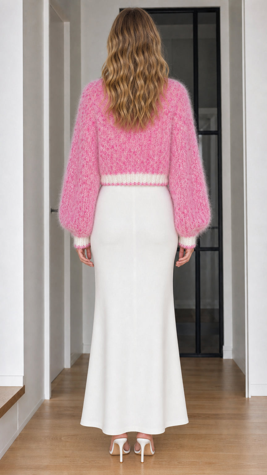 Back view of pink cropped fuzzy cardigan sweater and white knit skirt