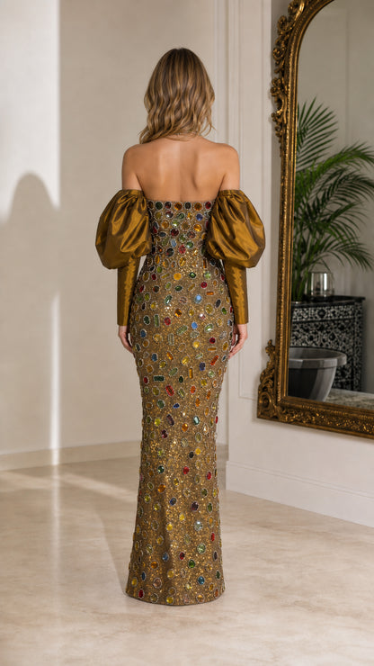 Back view of woman wearing gold jewel-encrusted strapless column gown