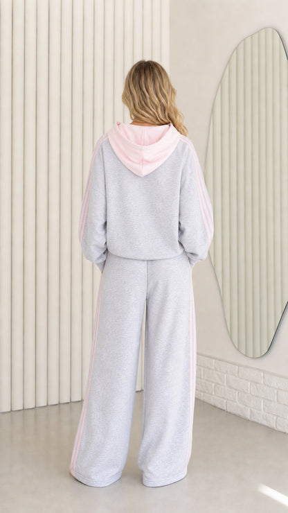 Back view of woman wearing Heather Grey tracksuit set showing pastel pink hood detail