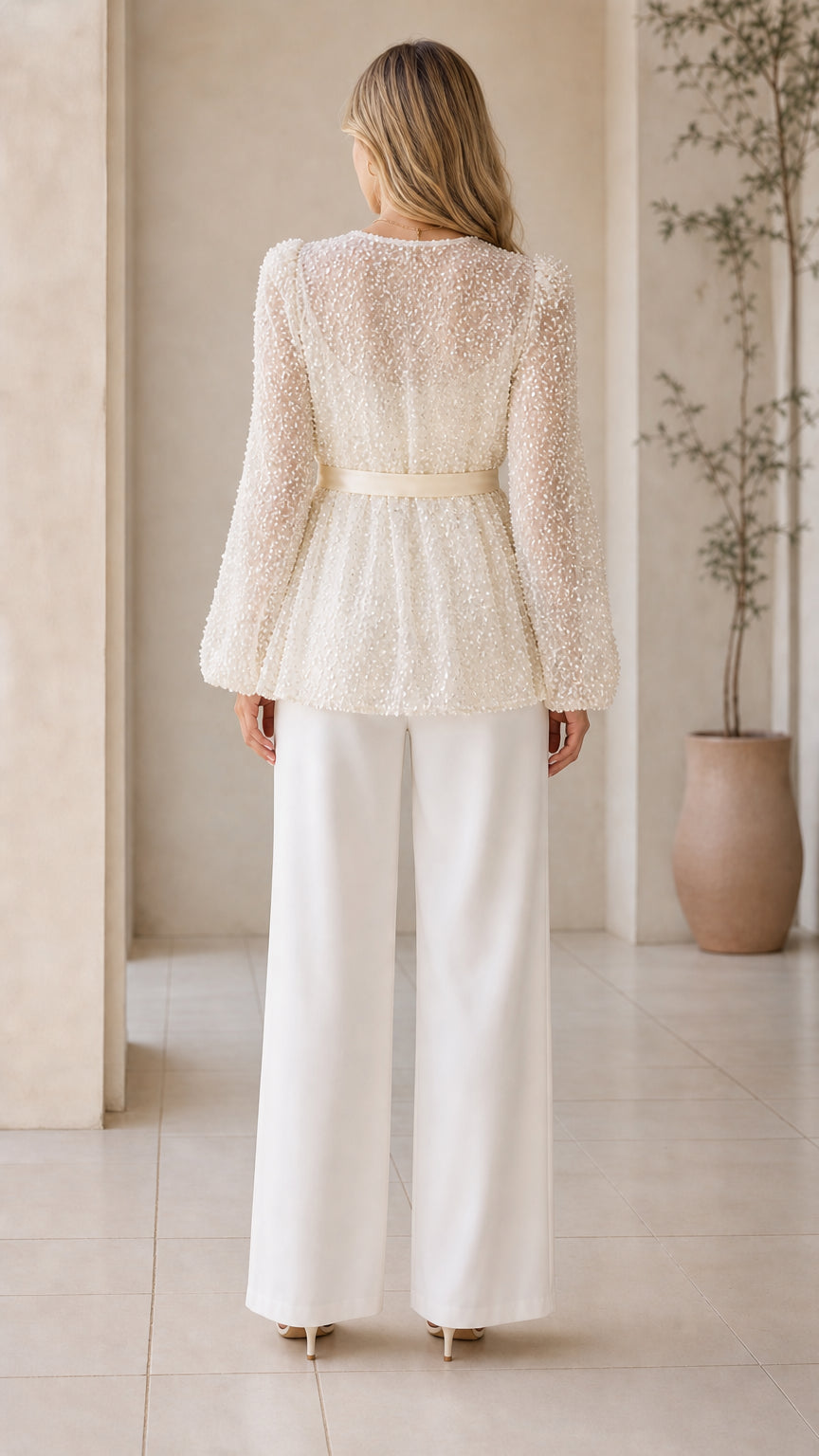 Back view of champagne sequin peplum jacket with tie waist sash