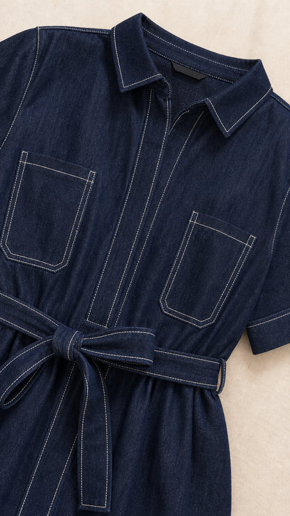 Close-up detail of dark blue midi dress showing collar, chest pocket, and white contrast stitching