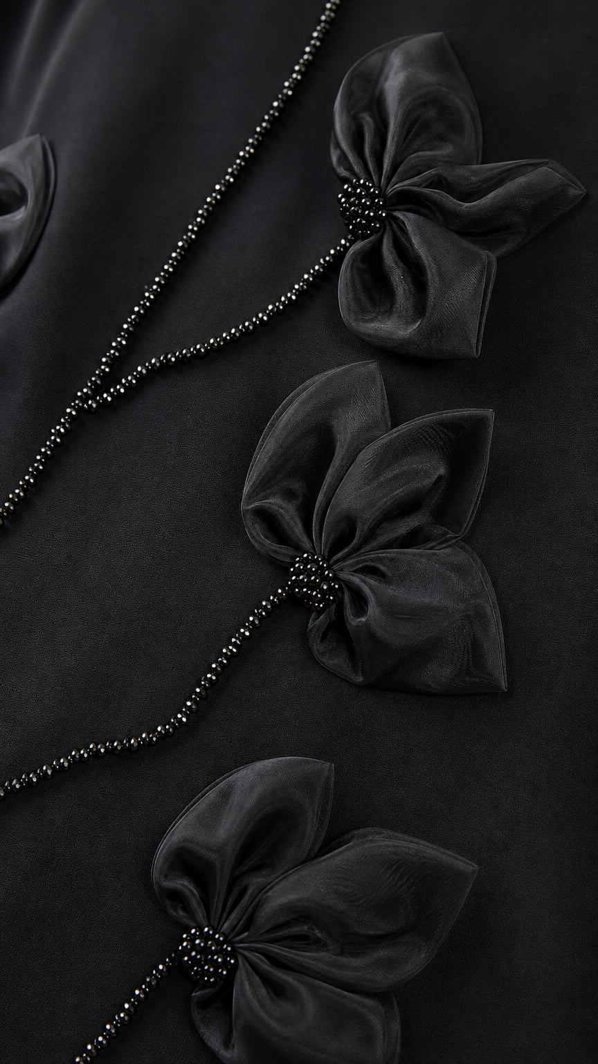 Close-up detail of 3D black flower petals and beaded vine embellishment