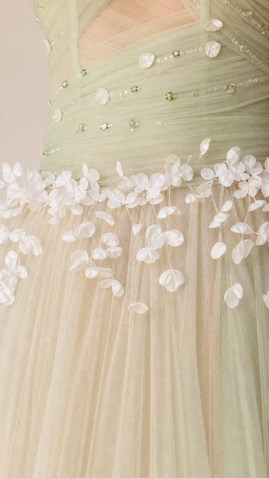 Close-up detail of sage green bodice showing beaded embellishment and delicate 3D floral appliqués
