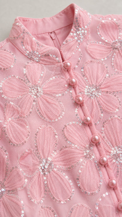 Close-up detail of mock neck, buttons, and sequin floral embroidery
