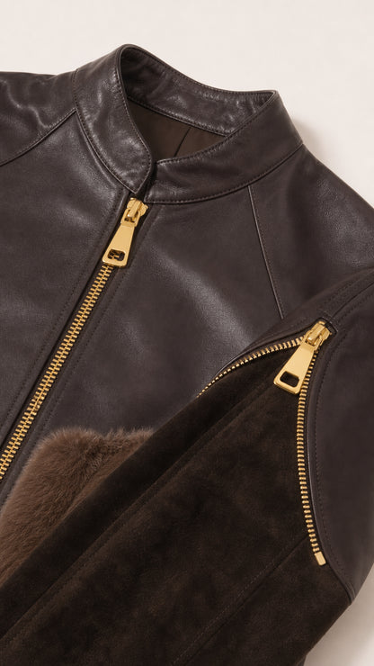 Close-up detail of collar, gold-tone zipper, and plush pocket trim on the jacket