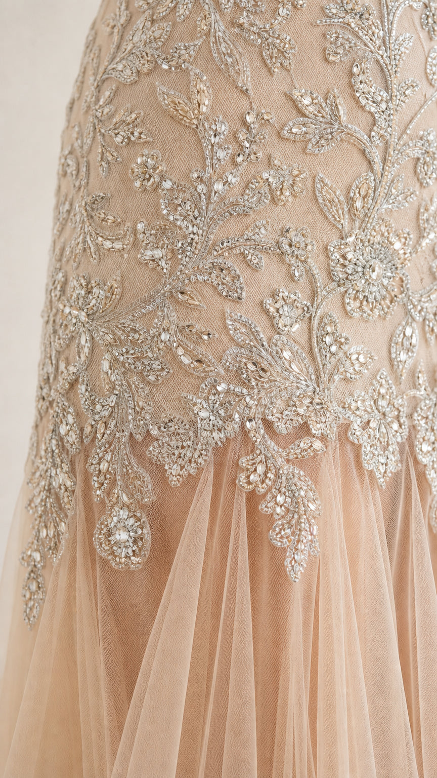 Close-up detail of intricate floral beadwork and sheer tulle hem