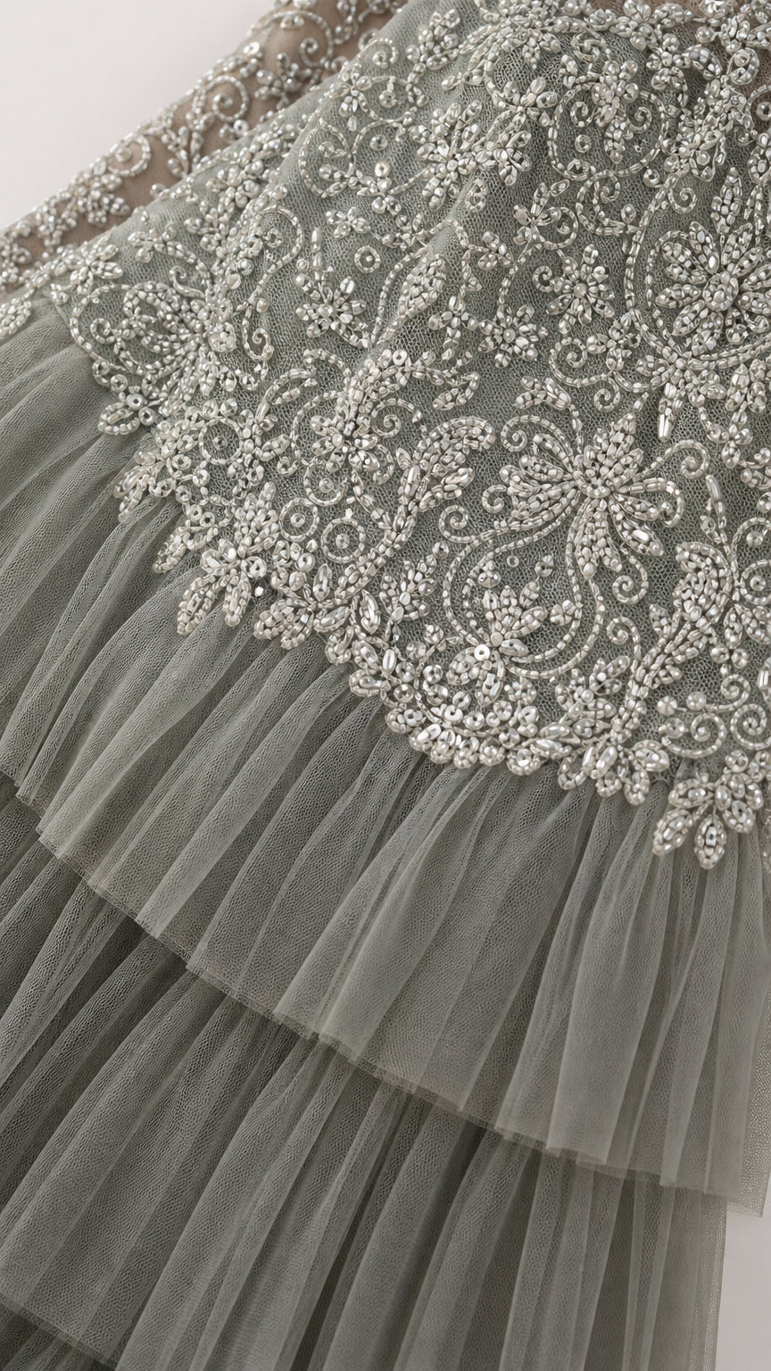 Close-up detail of delicate beadwork embroidery and pleated tulle skirt