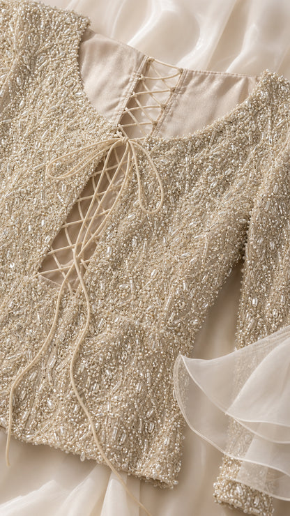 Close-up detail of intricate beadwork and lace-up back on Champagne evening dress