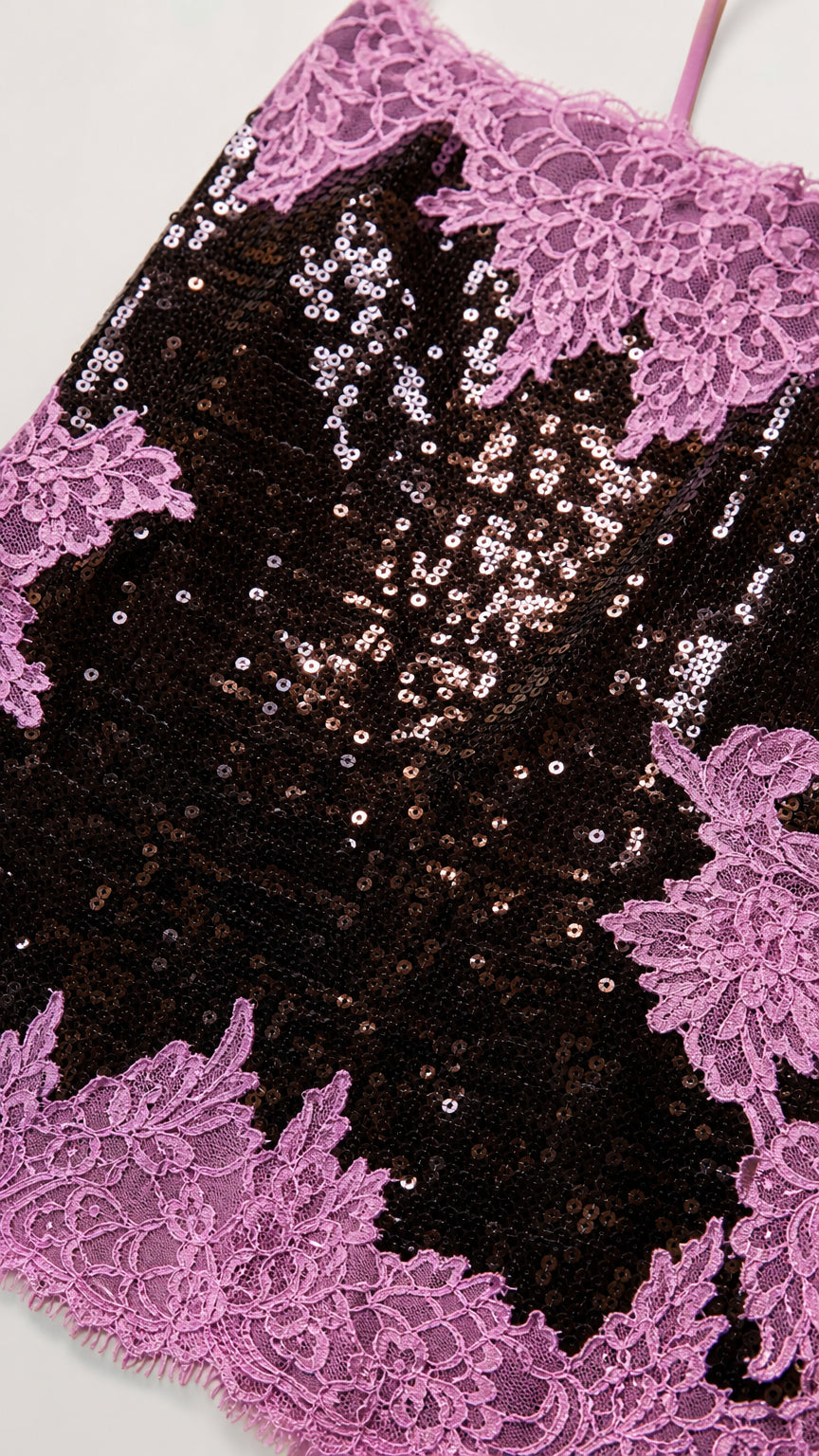 Close-up detail of black sequins and delicate pink floral lace embroidery
