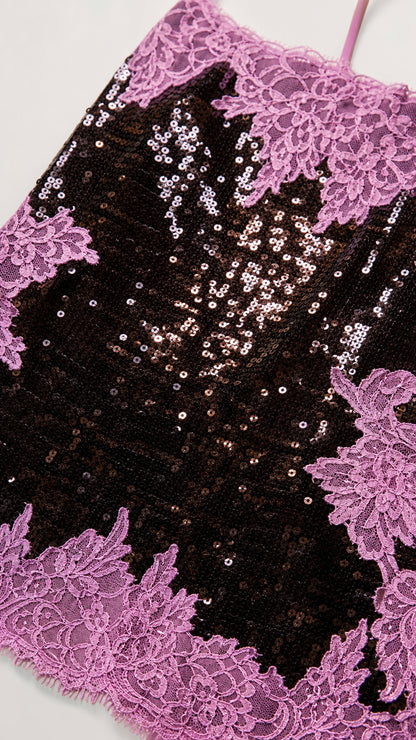 Close-up detail of black sequins and delicate pink floral lace embroidery