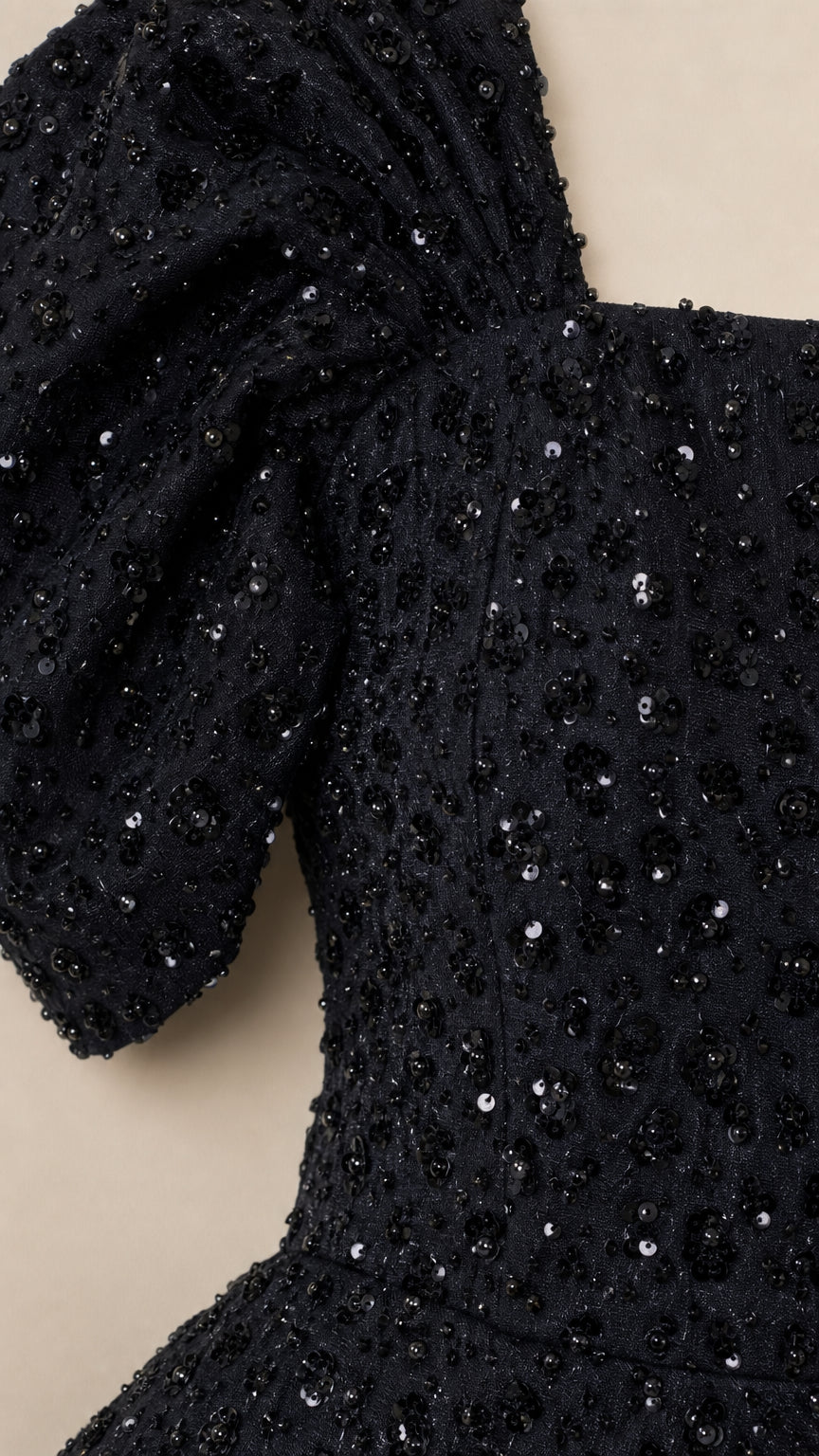 Close-up detail of gathered puff shoulder and intricate black sequin fabric