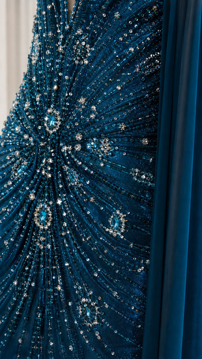 Close-up detail of intricate sunburst beadwork and sequins on teal fabric