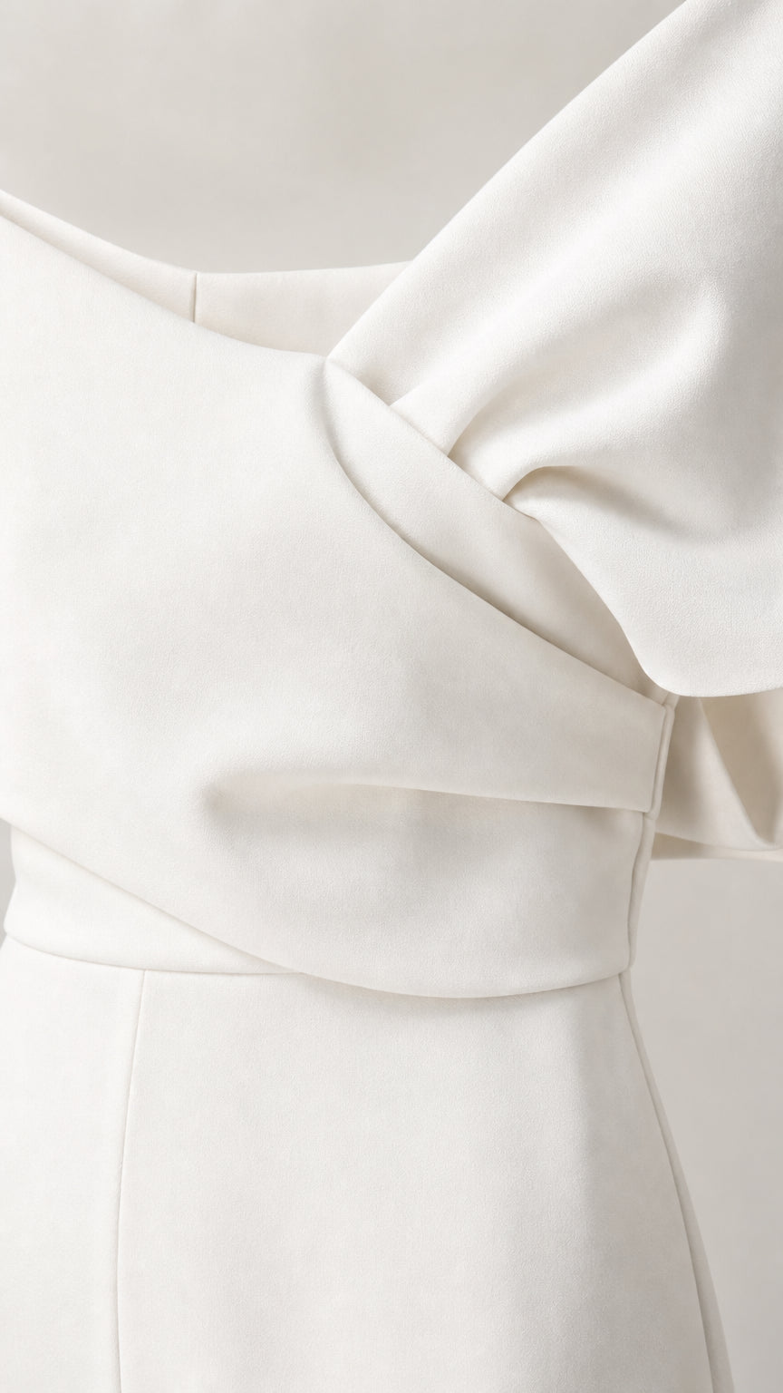 Close-up detail of draped bodice and fabric on white jumpsuit