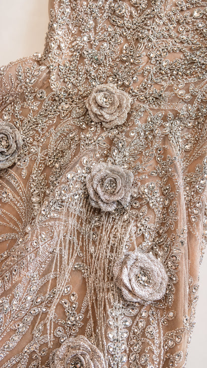 Close-up detail of silver embroidery, beads, and 3D floral rosettes