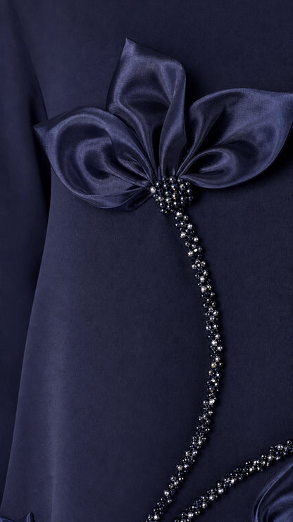 Close-up detail of 3D satin floral applique and bead embellishment