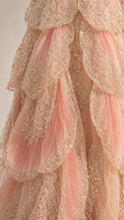 Close-up detail of scalloped layered tulle fabric with shimmering metallic embroidery