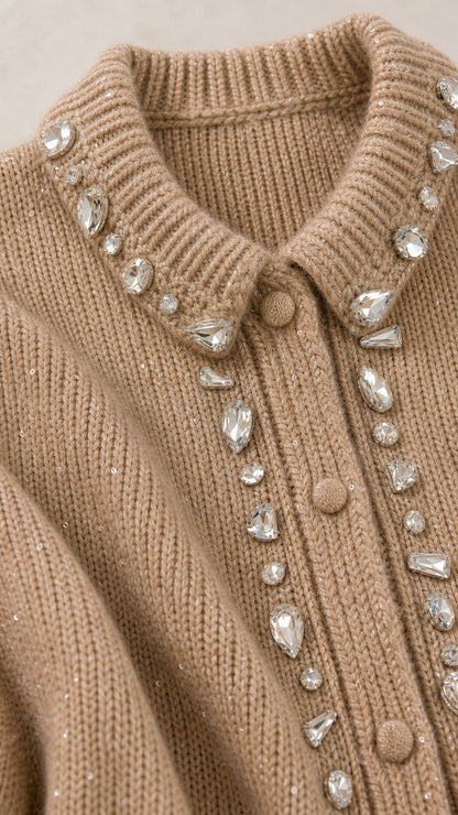 Close-up detail of sparkling crystal rhinestone embellishment along beige knit collar and button placket