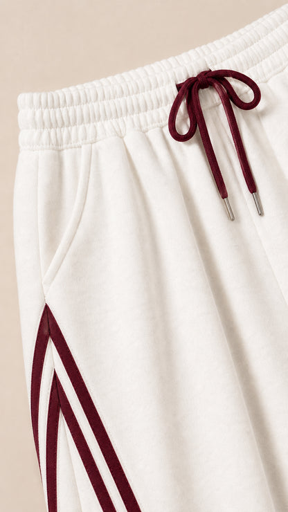 Close-up detail of elastic waistband, burgundy drawstring, and side stripe accent