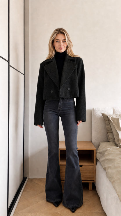 Model wearing black cropped double-breasted coat paired with dark wash flare jeans