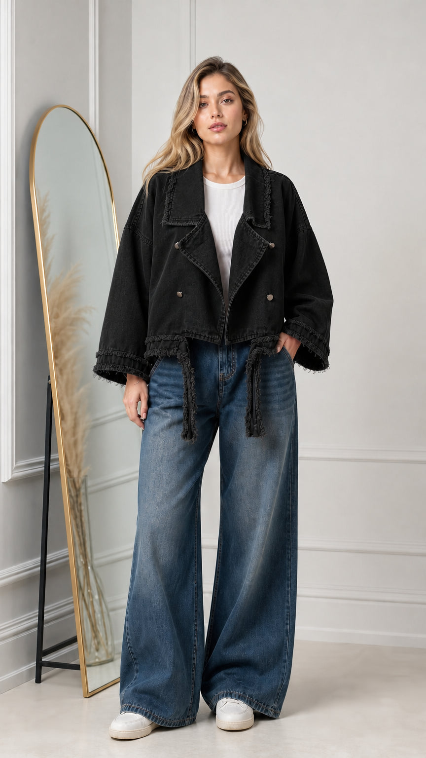 Model wearing washed black cropped frayed hem denim jacket with wide-leg jeans
