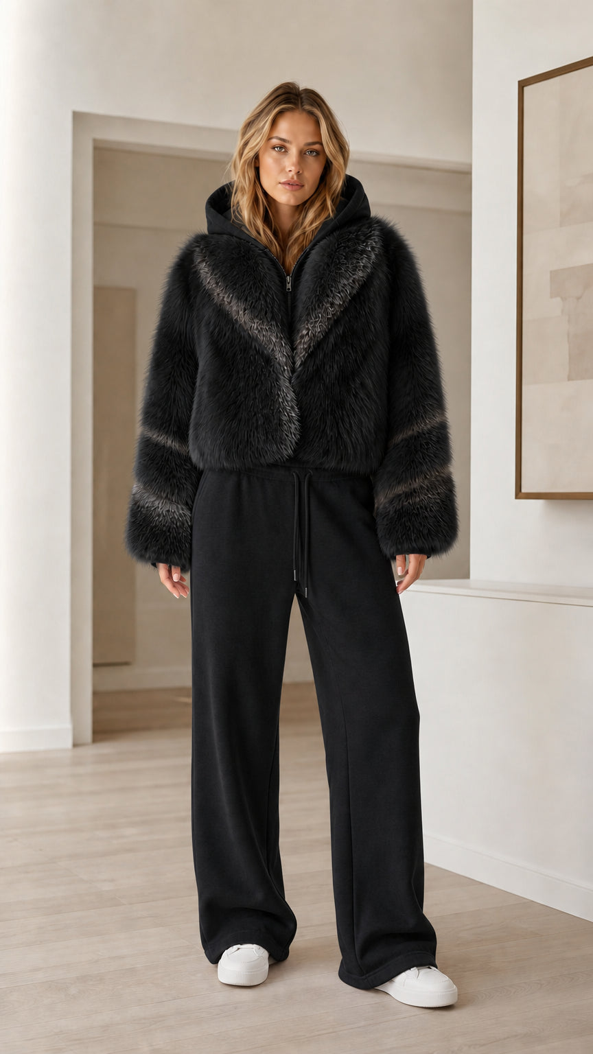 Model wearing black cropped faux fur hooded jacket with matching black wide-leg sweatpants