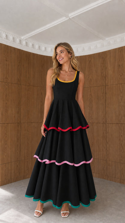Model wearing black sleeveless tiered maxi dress with contrast ribbon trims