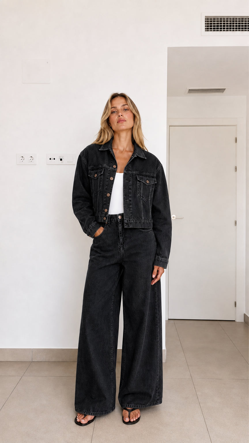 Woman wearing washed black 2-piece cropped denim jacket and wide-leg pants set
